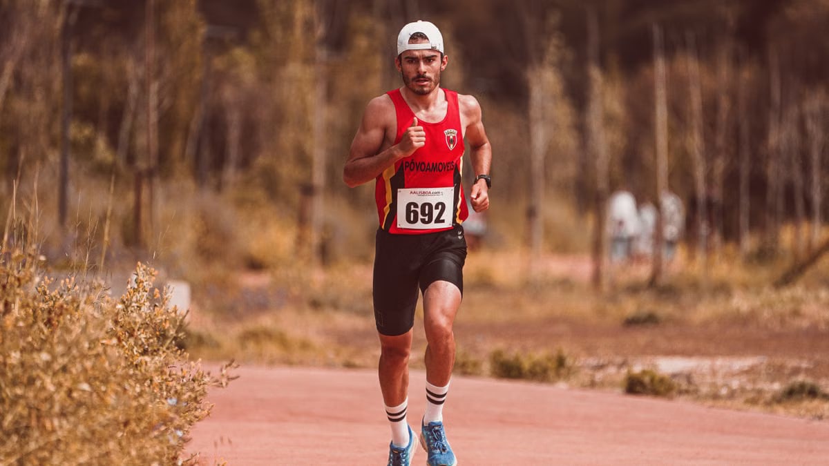 Athletic male runner participating in an outdoor marathon race on a sunny day.